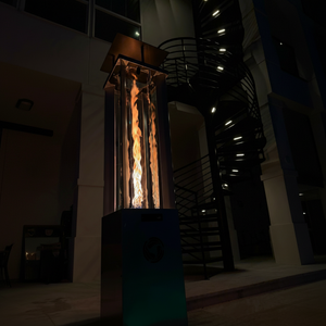 Tall outdoor fire pit with flames glowing in a dark setting