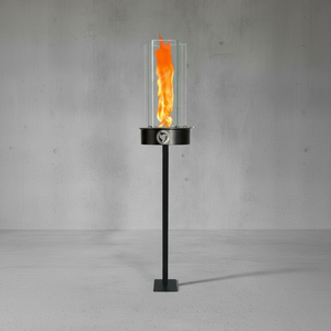 Black outdoor fire torch with flames on a gray concrete background