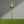 Garden torch with flame on a grassy area against a gray wall