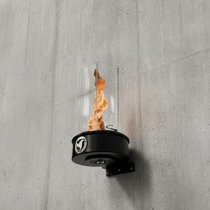 Outdoor oil fire feature with a vertical flame enclosed in a clear glass wind guard, mounted to an exterior wall using a metal wall bracket for patio and outdoor lighting.