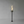 Tall black torch with flames inside a glass container on a gray background