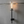 Wall-mounted candle holder with flame on a gray concrete wall