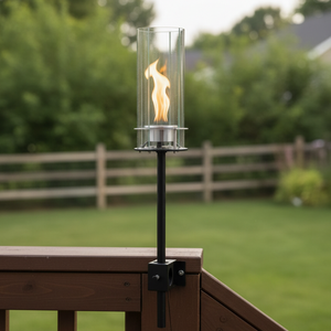Outdoor fire torch on a deck with a blurred garden background