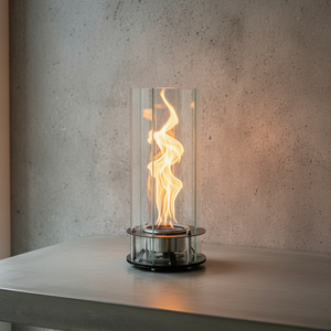 Modern table lamp with glass罩and flame-like design on a concrete surface.