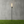 Torch-style outdoor light on a grassy area with a concrete wall background