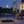 Outdoor patio scene with a lit garden torch, modern furniture, and a house in the background.