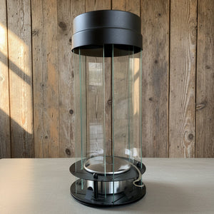 Modern black and glass cylindrical object on a wooden surface