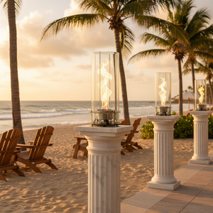 Beachside setting with fire lanterns on columns, palm trees, and ocean view.