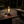 Modern table lamp with glass shade and visible flame on a neutral background