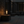 Modern table lamp with glass shade and visible flame on a neutral background