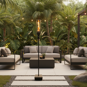 Outdoor gas tiki torch featuring a tall vertical flame, clear glass wind guard, and black metal base for modern patio, garden, and landscape lighting using propane or natural gas.