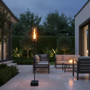 Outdoor gas tiki torch featuring a tall vertical flame, clear glass wind guard, and black metal base for modern patio, garden, and landscape lighting using propane or natural gas.