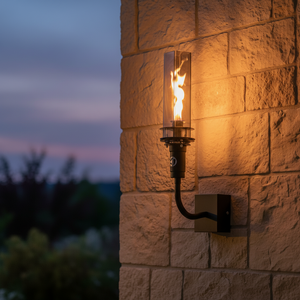Outdoor wall-mounted gas tiki torch with a tall vertical flame, clear glass wind guard, black metal wall mount arm, and rectangular wall plate, designed for modern patio, garden, and exterior wall lighting using propane or natural gas.