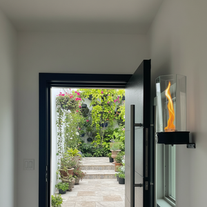 Modern indoor setting with a wall-mounted vortex flame burner and open door leading to a garden.