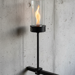 Wall-mounted torch with flame against a concrete wall