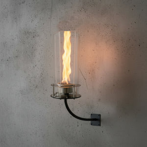 Wall-mounted light fixture with glass cover on a textured wall