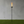 Torch-style lamp on a grassy area with a gray wall background