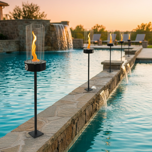 Poolside with fire torches and a waterfall in the background