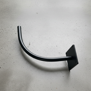 Black curved metal bracket on a gray concrete surface