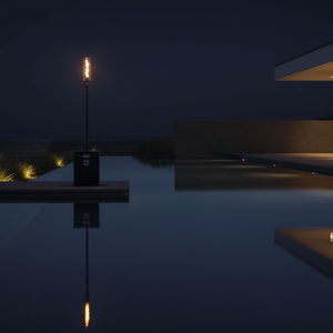 Modern house with a pool at night, illuminated by a single torch.