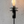 Black outdoor torch with a lit flame against a speckled wall background