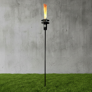 Torch-like lamp on grass with a concrete wall background