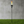 Torch-like lamp on grass with a concrete wall background