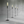 Set of four tall floor lamps with flame-like lights on a reflective surface.