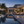 Modern outdoor living area with pool, fire pit, and palm trees at dusk.