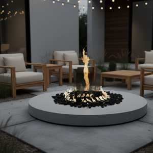 Outdoor gas fire pit base with a central vertical flame, clear glass wind guard, circular burner surround, and decorative fire media, designed for modern patio, garden, and outdoor living spaces using propane or natural gas.
