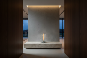 Modern outdoor fireplace with flames on a concrete surface and gray background