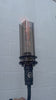 Modern outdoor gas fire torch with visible flame inside a clear glass tube, wall-mounted black metal torch for patio, backyard, and outdoor entertainment lighting.