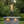 Post mounted vortex fire torch for column and pillar installations, featuring a tall vortex flame, clear glass wind guard, and black powder-coated body, compatible with natural gas or propane for luxury outdoor patios and commercial landscapes